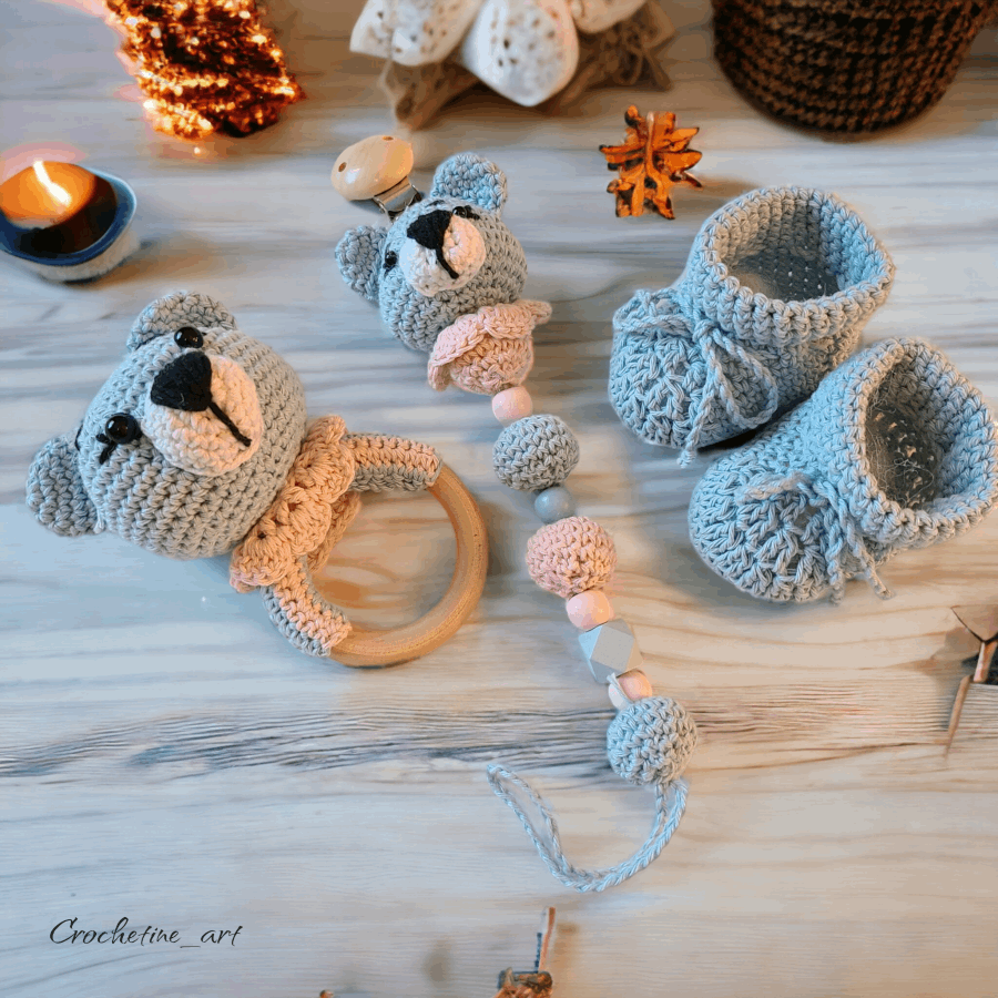 Coffret cadeau de naissance pour bébé au crochet comprenant un hochet, une paire de chausson taille 0 à 3 mois, une dragonne pour tétine ourson réalisé au crochet avec fil coton bleu et perle de bois