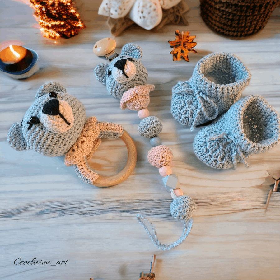 Coffret cadeau de  naissance pour bébé au crochet comprenant un hochet, une paire de chausson taille 0 à 3 mois, une dragonne pour tétine ourson réalisé au crochet avec fil coton bleu et perle de bois