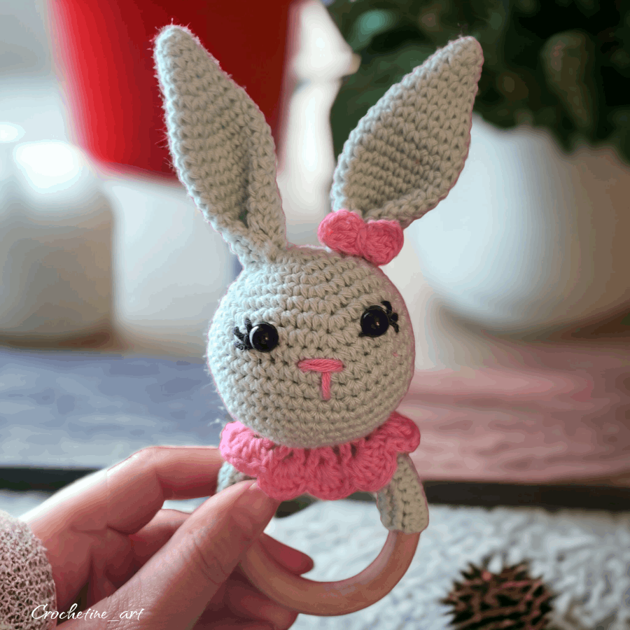 Hochet lapin de couleur vert d'eau et rose au crochet artisanal en fil coton. avec anneau de dentition en bois naturel 