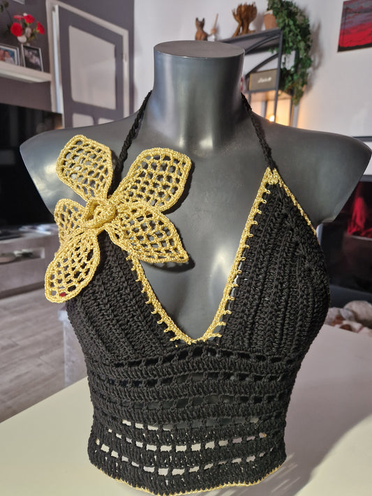 top réalisé au crochet de couleur noir et or avec une grosse fleur crochetée
