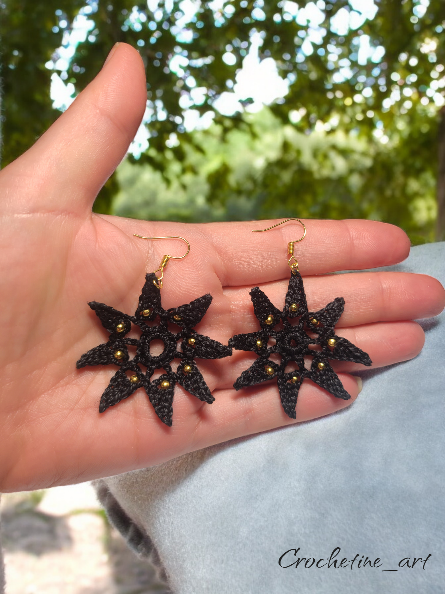 Boucles d'oreilles étoile Véga au crochet de couleur noire avec perles dorées.