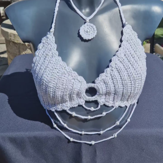 Haut crop top fait main au crochet de couleur blanc et argenté orné de perles argentées.