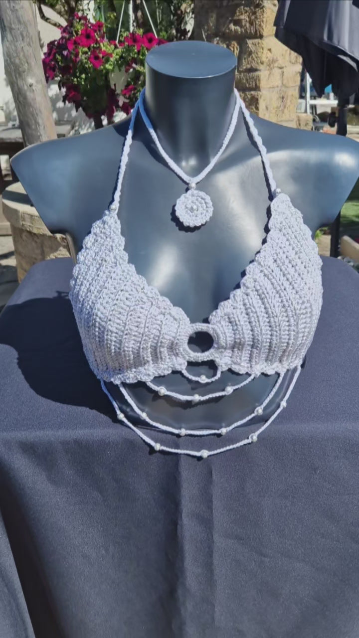 Haut crop top fait main au crochet de couleur blanc et argenté orné de perles argentées.